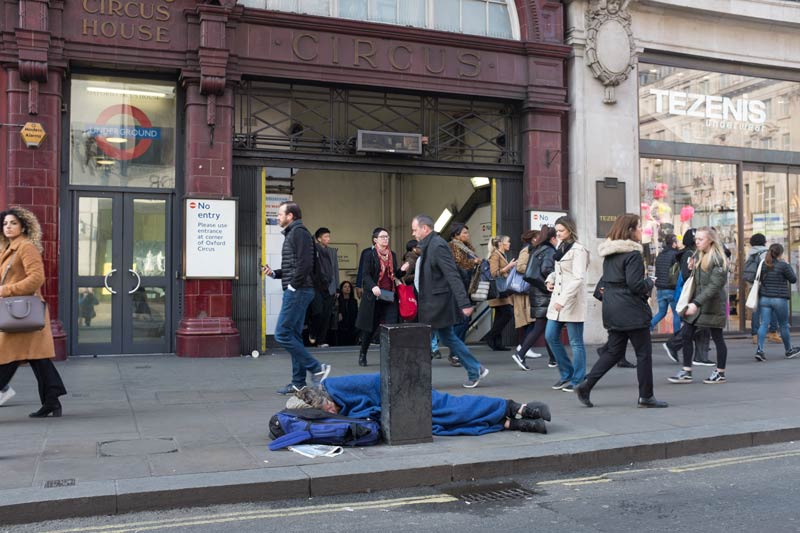 Man sleeping rough outside an exit to Oxford Circus tube station during the Extinction Rebellion protest in London