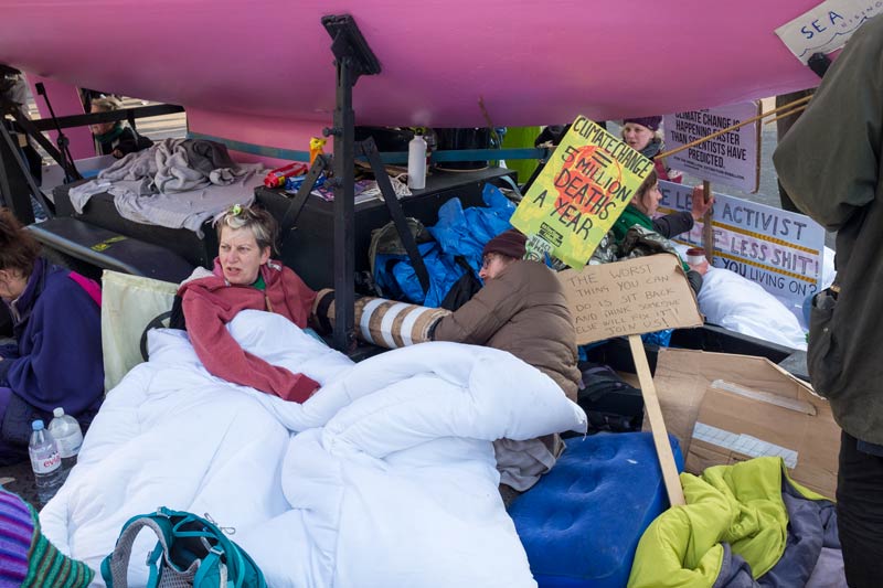 Chained together behind the struts propping up the boat during the Extinction Rebellion protest