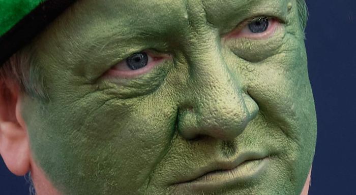 Man with green face lost in thought