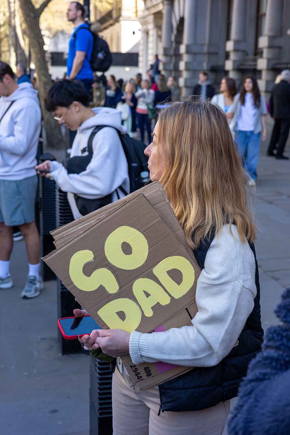 Woman holding 'Go Dad' placard at the London Landmarks 2025 half marathon in London
