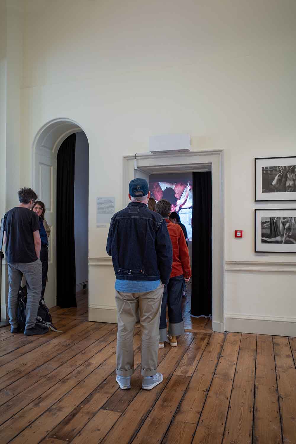 People looking at a film of Susan Meiselas' Carnival Strippers